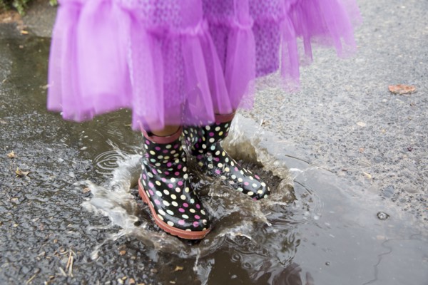 Mixed race girl playing in puddle