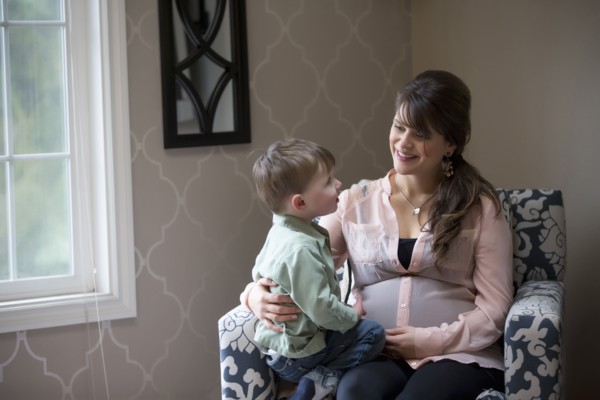 Pregnant Caucasian mother sitting with son