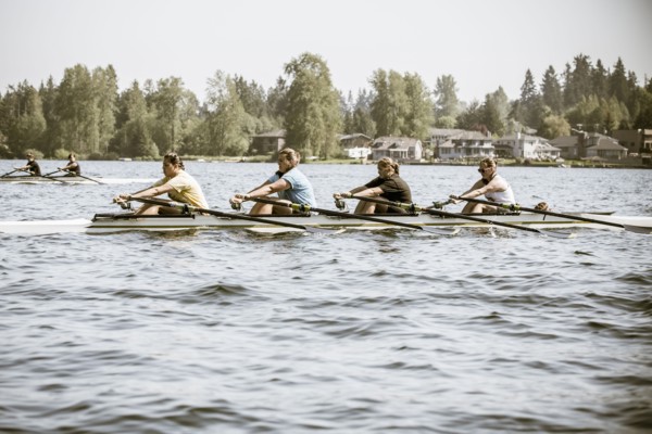 Teenagers rowing scull on lake