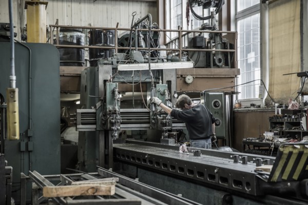 Caucasian man using machinery in metal shop