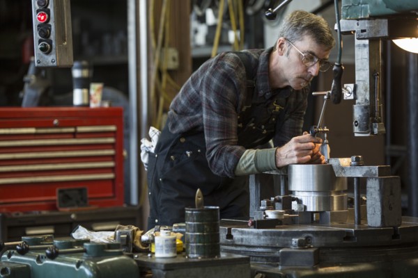 Caucasian man using machinery in workshop