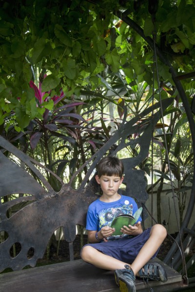 Caucasian boy reading on bench