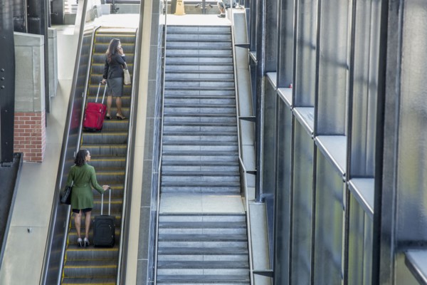 Businesswomen riding escalator