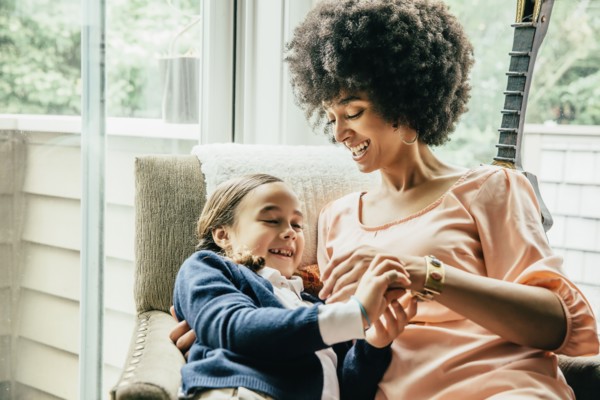 Mixed race mother holding daughter in armchair