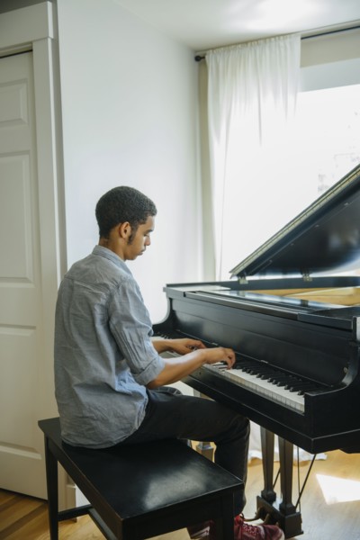 Mixed race boy playing piano
