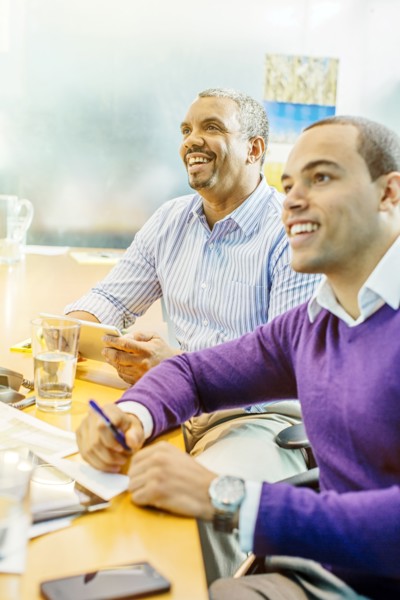 Businessmen laughing in office meeting