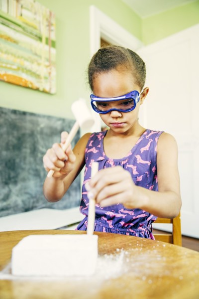 Mixed race girl doing science experiment at home