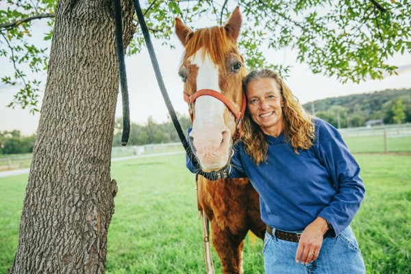 Caucasian woman hugging horse on farm