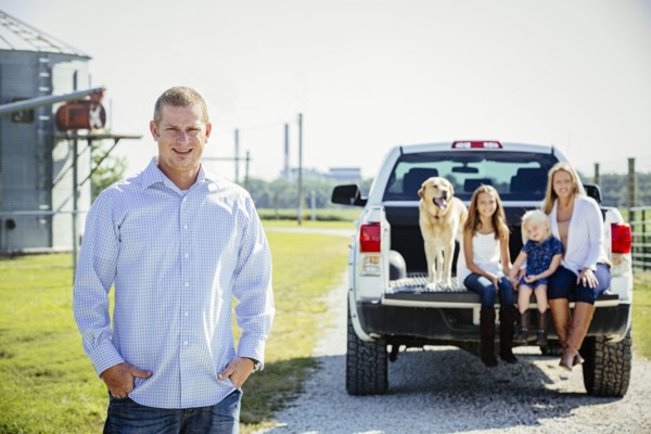 Caucasian man standing near family in truck bed