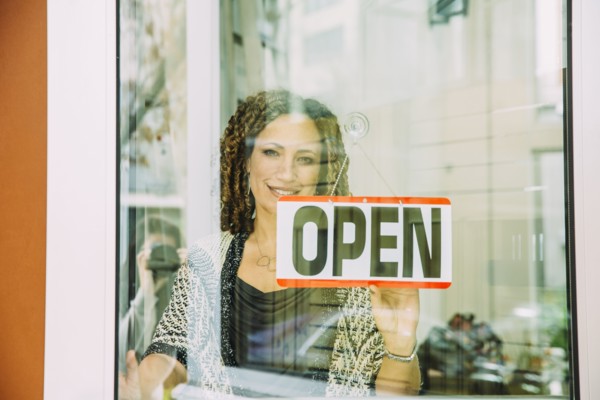 Mixed race store owner opening door