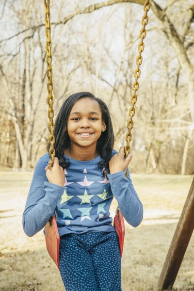 Black girl sitting on swing