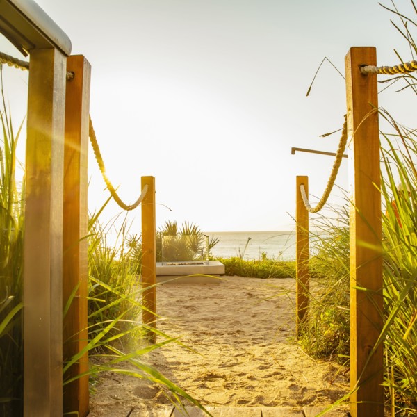 Walkway to beach under blue sky