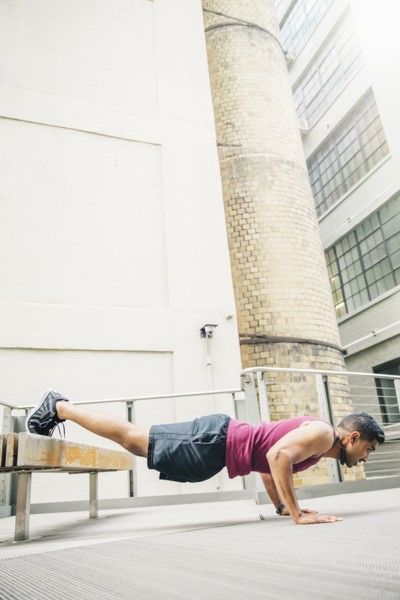 Indian man doing push-ups on bench