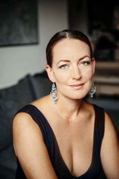 Caucasian woman in evening gown sitting on sofa