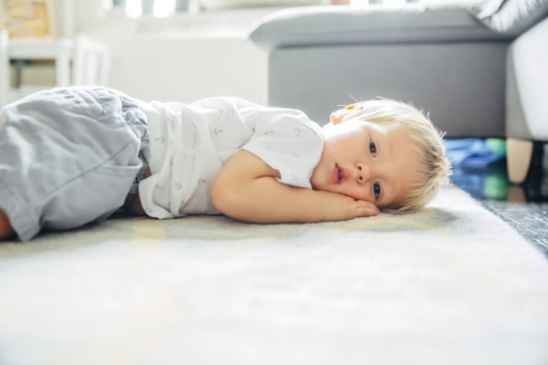 Mixed race boy laying on living room floor