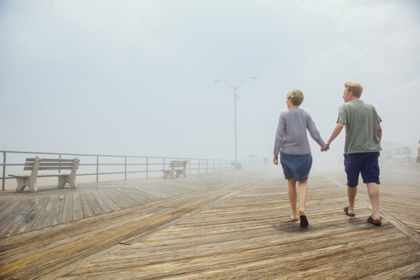 Couple holding hands on wooden boardwalk
