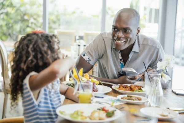 Father and daughter eating at restaurant