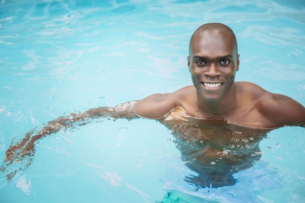 Black man swimming in pool