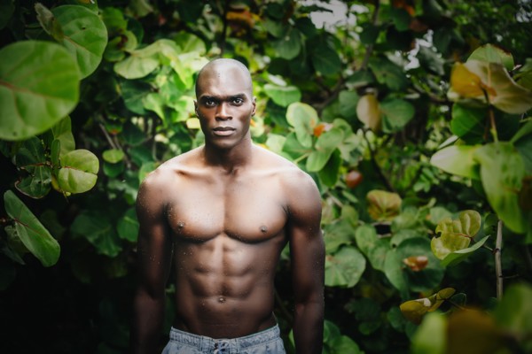 Black man standing in lush garden