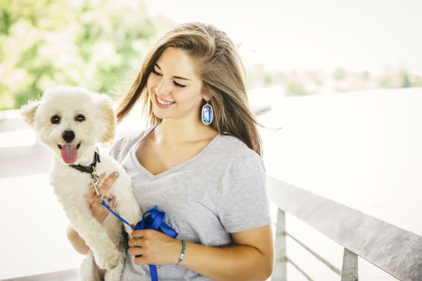 Caucasian woman carrying dog outdoors