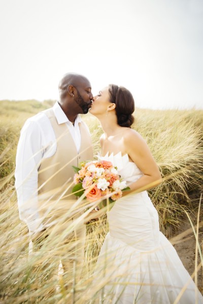 Newlywed couple kissing in grass