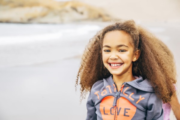 Mixed race girl smiling on beach