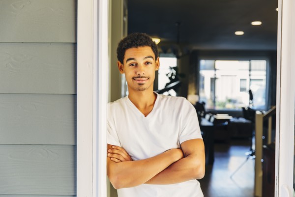 Mixed race man leaning on doorway