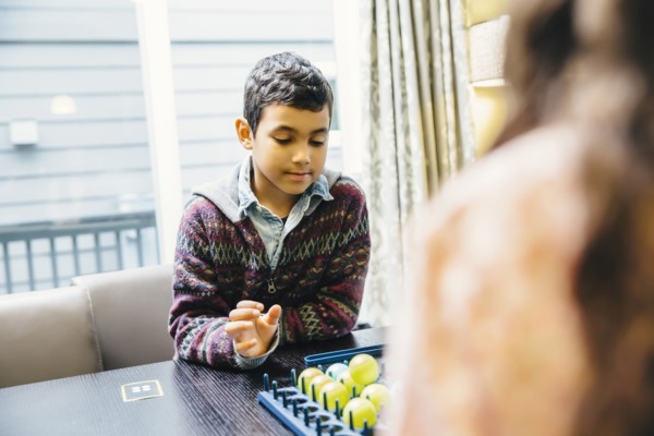 Mixed race siblings playing board game