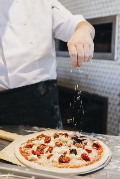 Chef making pizza in restaurant in kitchen