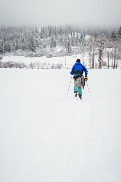 Caucasian woman cross-country skiing in snowy field