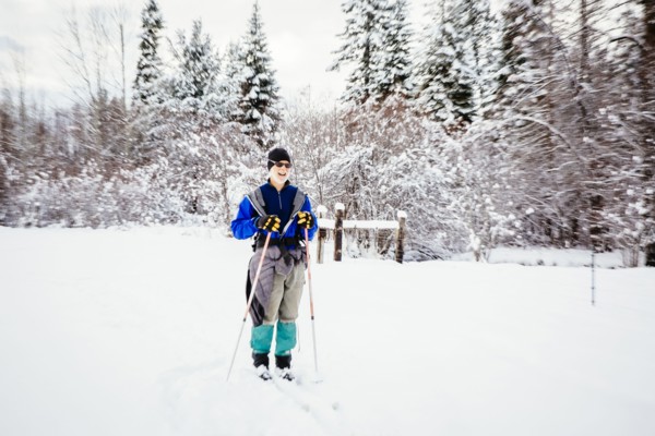 Caucasian woman cross-country skiing in snowy field