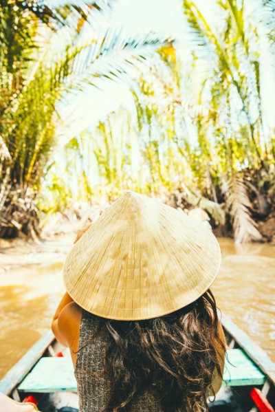 Caucasian woman floating in boat on rural river