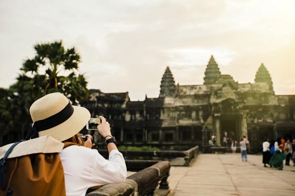 Caucasian tourist photographing Angkor Wat ruins