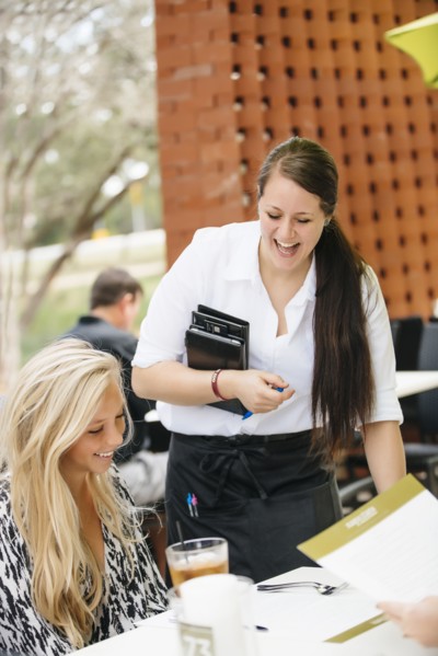 Smiling Caucasian waitress assisting customer
