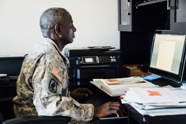 Black soldier using computer