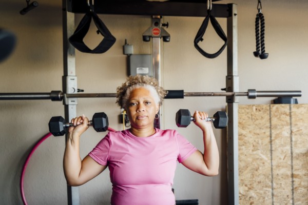 Black woman lifting weights in garage