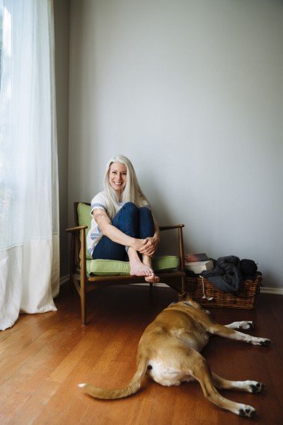 Caucasian woman sitting in armchair near dog