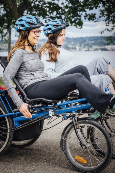 Caucasian mother and daughter riding tandem bicycle