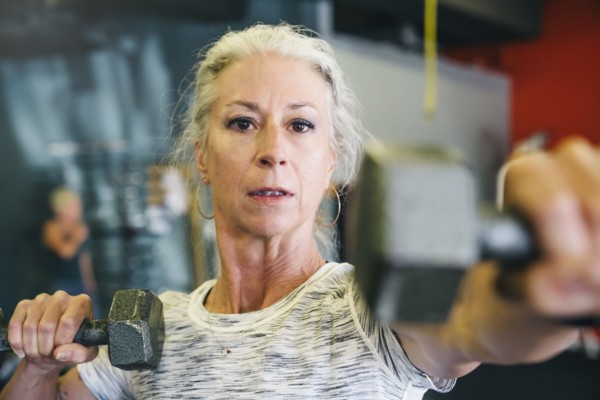 Caucasian woman lifting dumbbells in gymnasium