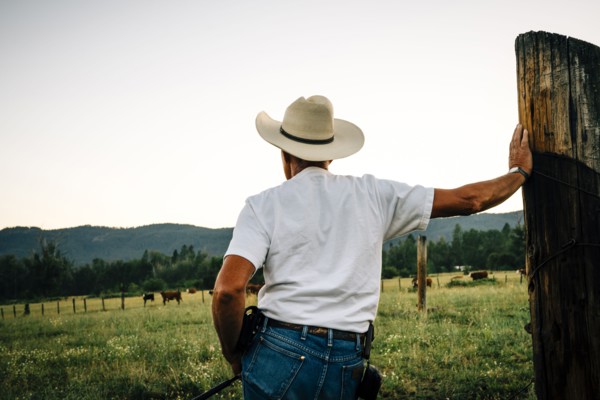 Caucasian farmer leaning on wooden post