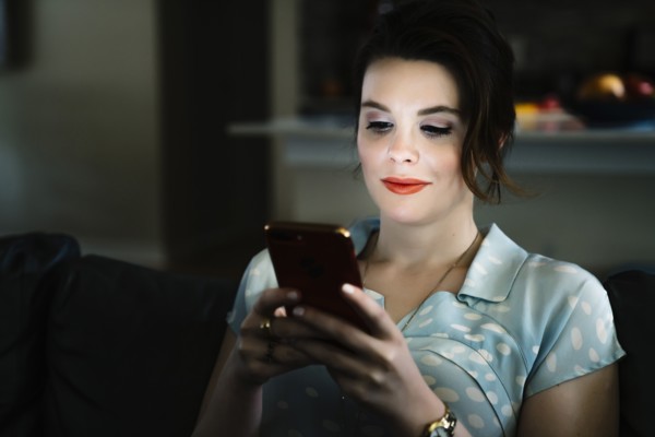 Woman texting on cell phone in the dark