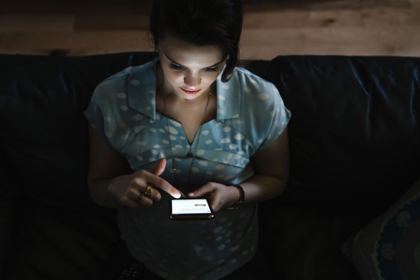 Woman texting on cell phone in the dark