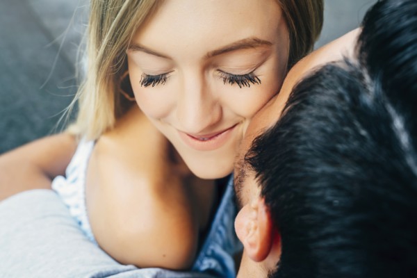 Caucasian man hugging woman and kissing her on cheek