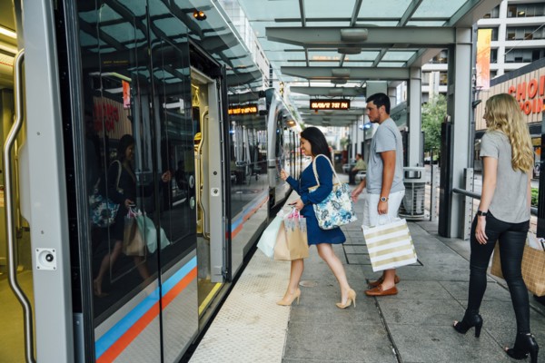 Friends boarding train carrying shopping bags