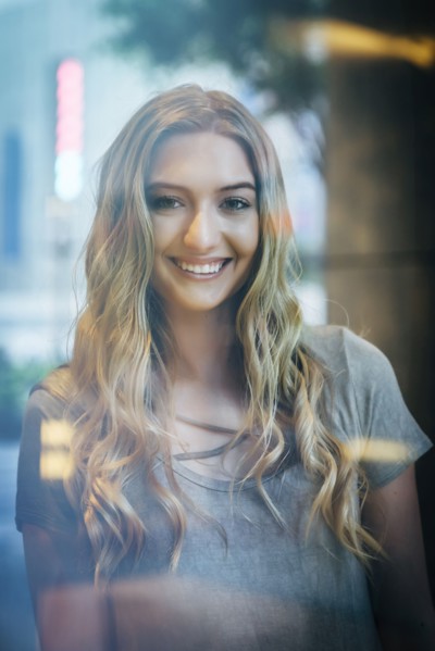Portrait of smiling Caucasian woman behind window