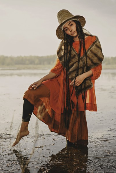 Caucasian woman wearing traditional clothing wading in water