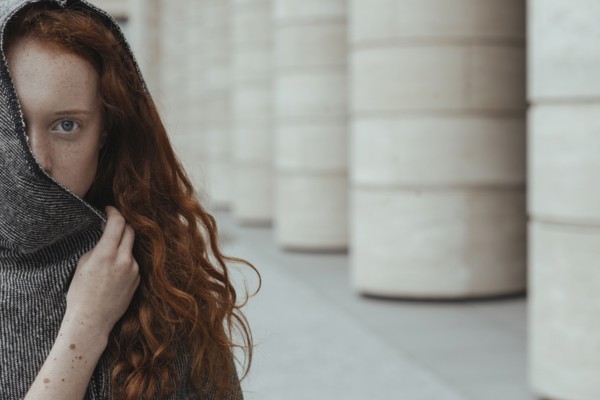 Caucasian woman hiding face behind hood