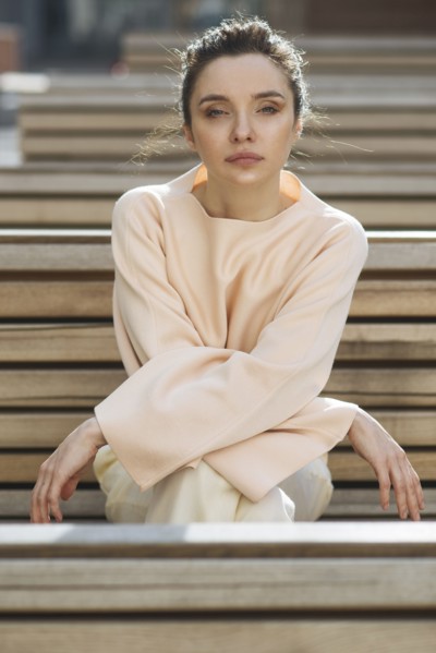 Portrait of serious Caucasian woman sitting on wooden bench