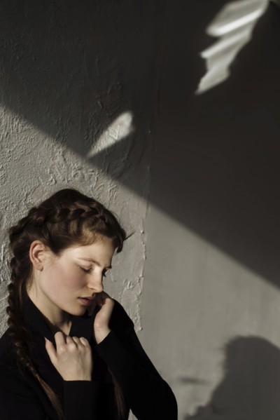 Shadow on wall over pensive Caucasian woman