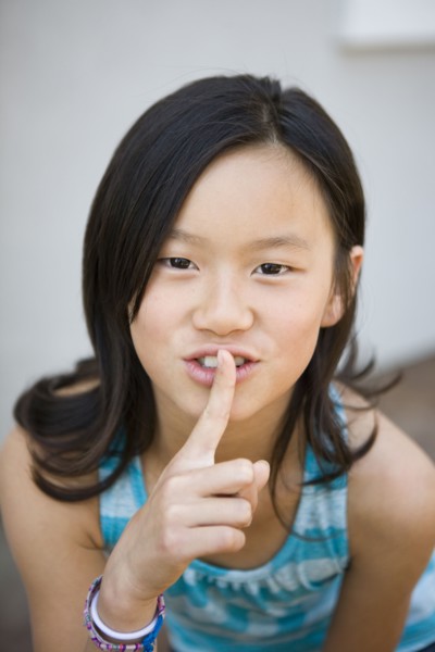 Chinese girl making shhh gesture